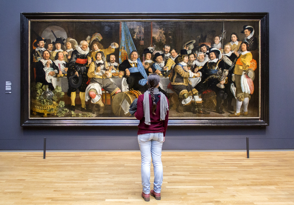 photo-of-girl-with-braid-in-hair-looking-at-big-painting-in-a-museum-purple-wall-scarf