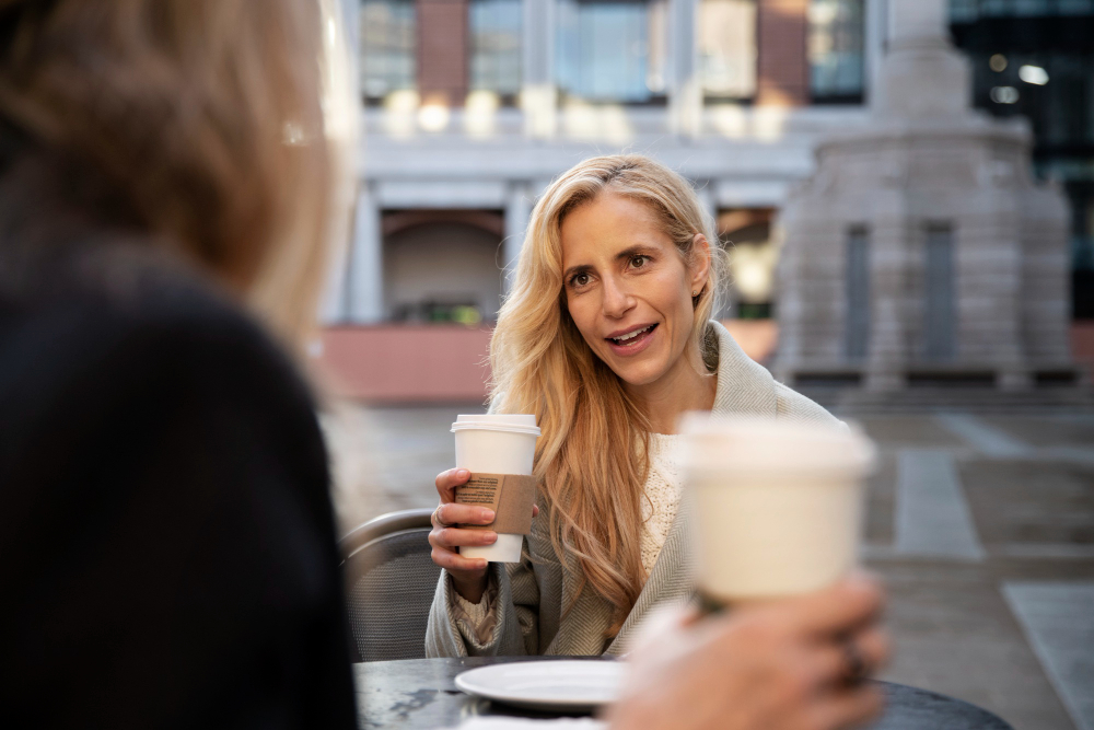 photo-of-woman-talking-to-another-person-after-learning-how-to-say-how-are-you-in-Dutch-while-drinking-coffee-outside