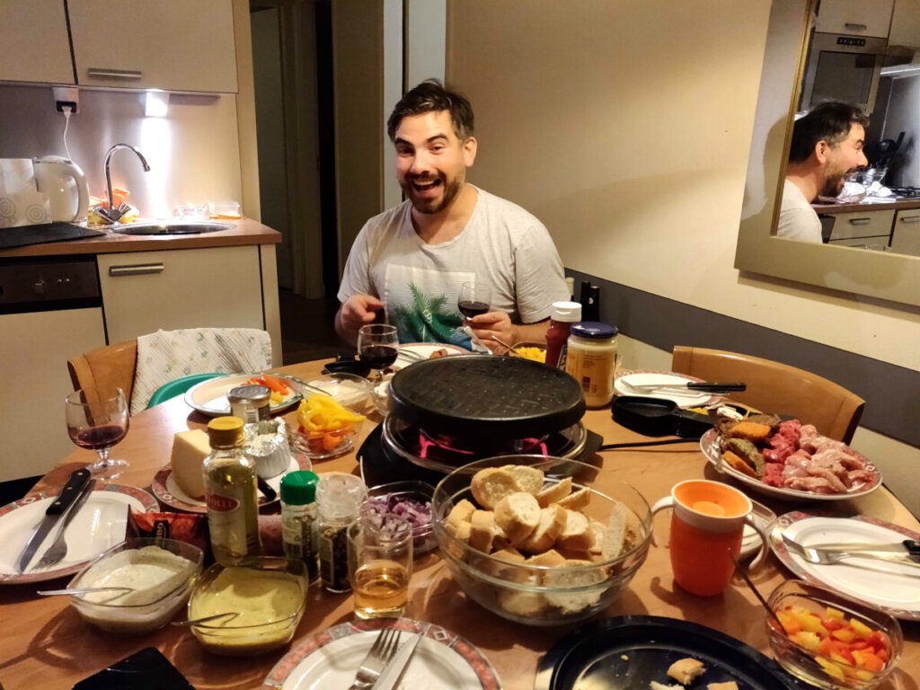 Man-sitting-at-table-with-gourmet-grill-and-glass-of-wine-in-hand-during-Christmas-holidays-in-the-Netherlands