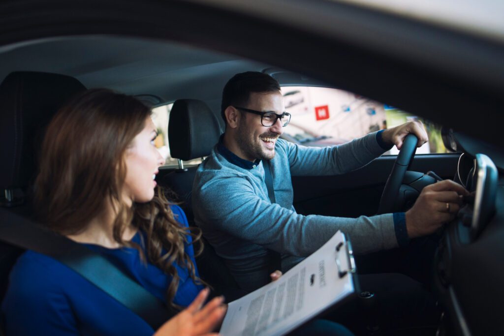 photo-of-man-smiling-at-driving-test-instructor-during-drivers-exam-netherlands