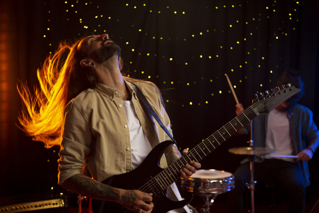 photograph-of-a-long-haired-man-playing-guitar-onstage